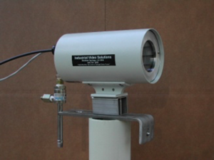 It has long been a desire to be able to see inside a vessel or reactor  without having to go out and physically go look into the sight glass.  All of our fixed mount cameras are available in a vessel mount version.  With a simple bracket that attaches to one of the sight glass bolt, the  camera slides right up to the sight glass to give the operator a remote  view. Some applications require lighting as well. Therefore, we offer  high performance LED lighting systems housed in similar enclosures to  illuminate those dark vessel interiors. Cooling options are also  available. Available in both analog and IP versions.